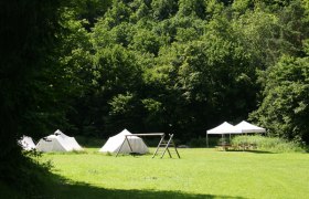 Zeltplatz Waldbad Hardegg, © Stadtgemeinde Hardegg Zelte und Pavillon auf einer grünen Wiese vor einem Wald.