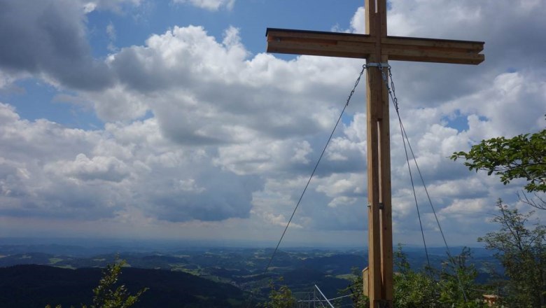 Gipfelkreuz, Aussichtsberg Burgsteinmauer, © Leo Baumberger Gipfelkreuz auf dem Aussichtsberg Burgsteinmauer mit Blick auf bewölkten Himmel und Landschaft.