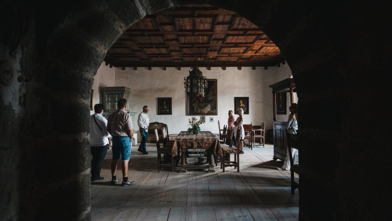 Burg Heidenreichstein, © Waldviertel Tourismus, Line Sulzbacher Innenansicht eines historischen Raumes mit Besuchern, Holzmöbeln und Gemälden an den Wänden.