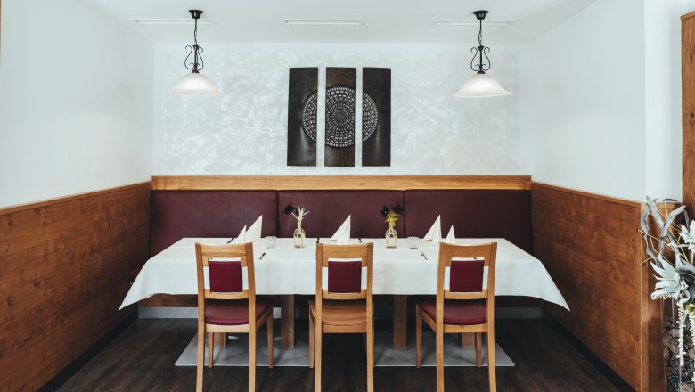 Innovation meets tradition in Groß Gerungs, © Niederösterreich Werbung/David Schreiber A stylishly laid table in a restaurant with wood paneling and modern art on the wall.