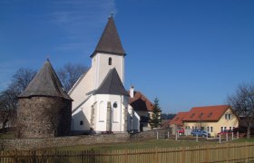 Kirche und Gebäude in Großgöttfritz bei klarem Himmel.