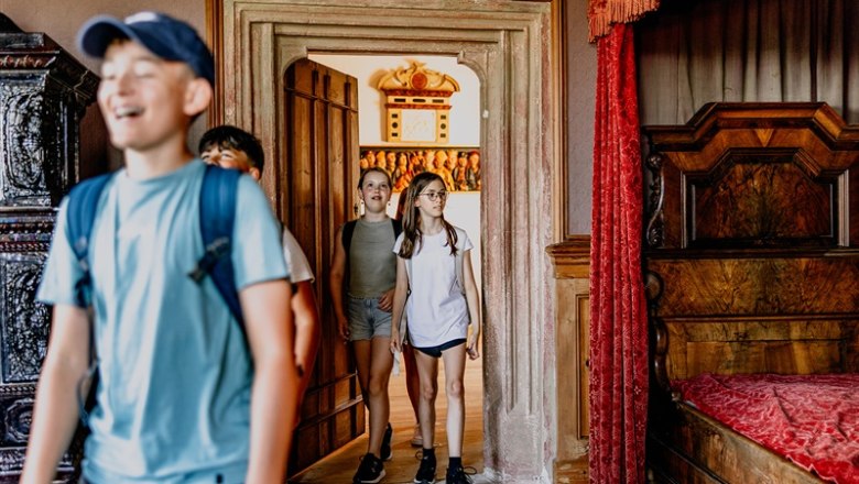 Kinder betreten einen Raum in einem Renaissanceschloss.