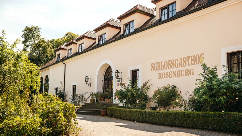 Außenansicht des Schlossgasthofs Rosenburg mit Garten und Eingangstreppe.
