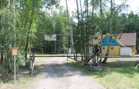 Eingang zu einem Lagerplatz mit einem gelben Gebäude im Hintergrund.