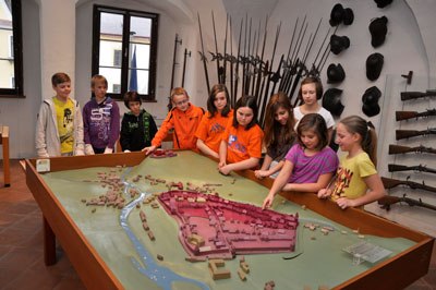 Kinder betrachten ein Stadtmodell in einem Museum.