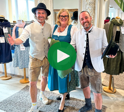 3 lachende Personen in Tracht mit Blick in die Kamera