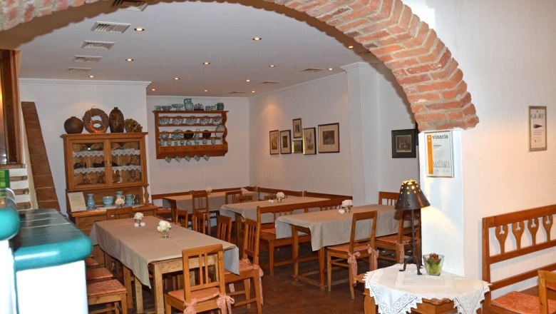 Gemütlicher Innenraum eines Heurigen mit Holzmöbeln und Dekorationen.