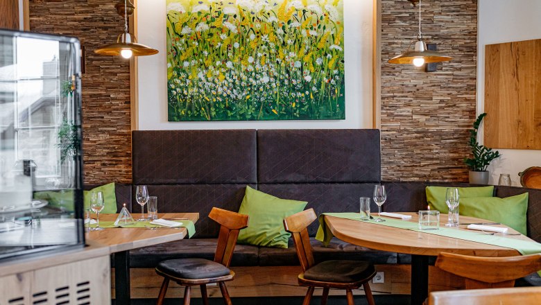 Cozy guest room with wooden furniture, green cushions and a flower picture on the wall.