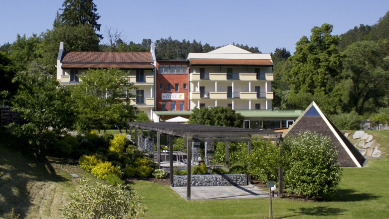 Exterior view of a hotel with garden and pavilion.