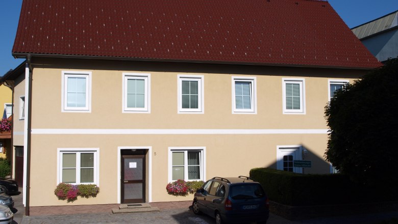 Ferienwohnungen Nöbauer, © Familie Nöbauer Gelbes zweistöckiges Haus mit rotem Dach und mehreren Fenstern.