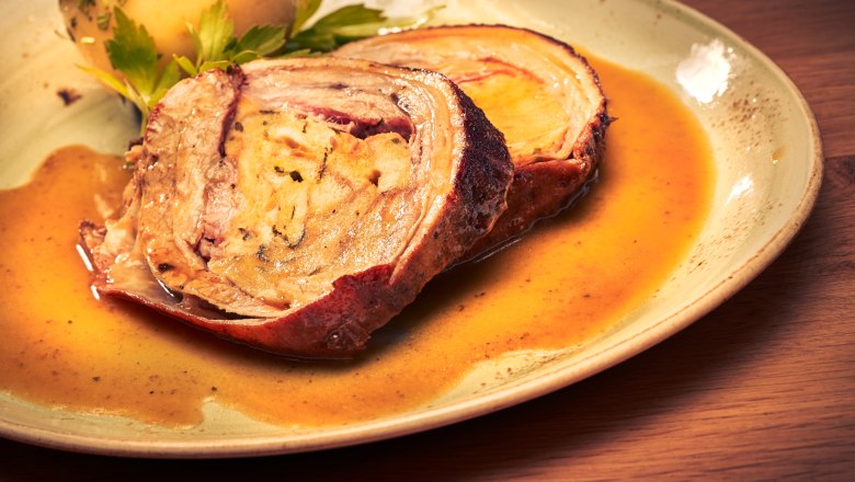 A plate with roast and potatoes in gravy.