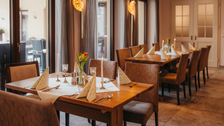 A cozy table in an inn with candles and flowers.