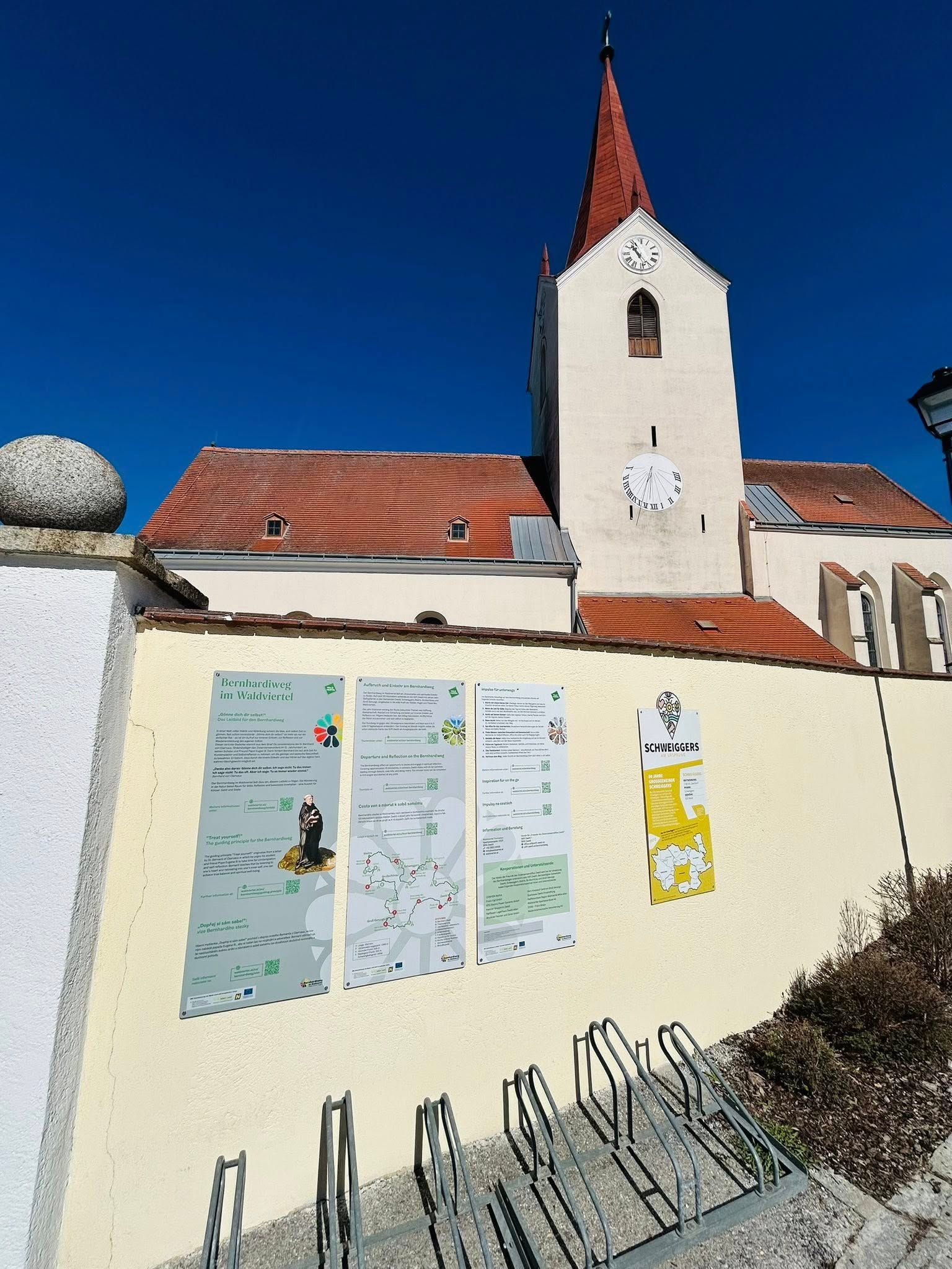 Tafeln zum Bernhardiweg bei einer Kirche.
