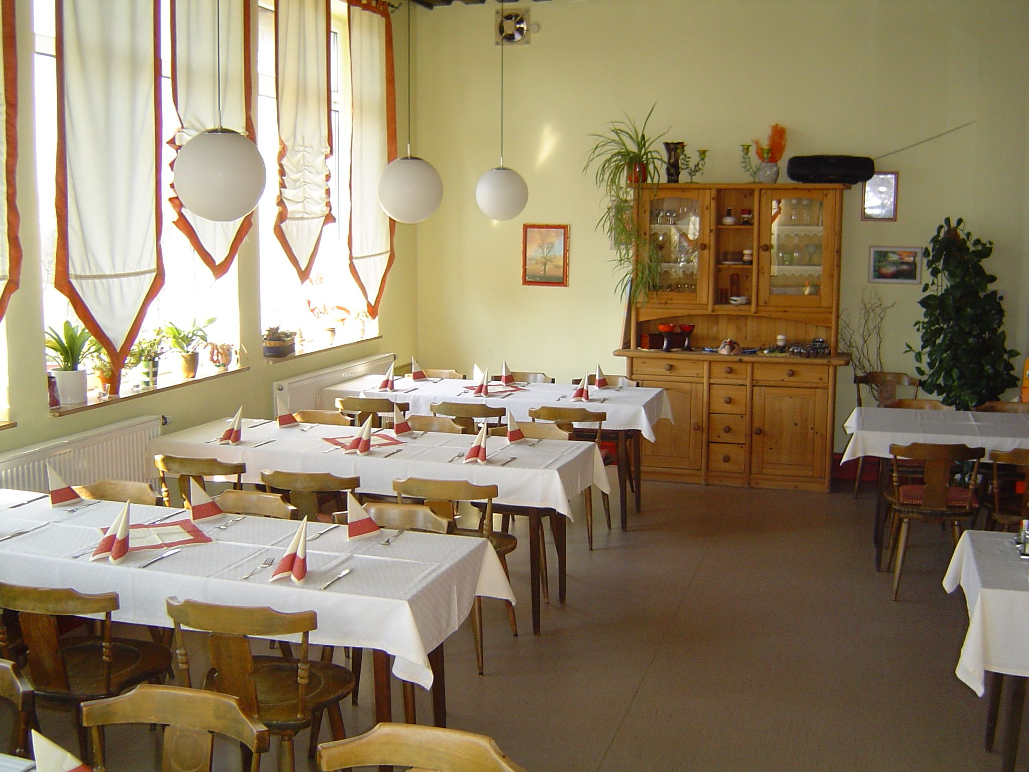 Innenansicht eines gemütlichen Cafés mit Holzmöbeln und dekorierten Tischen.