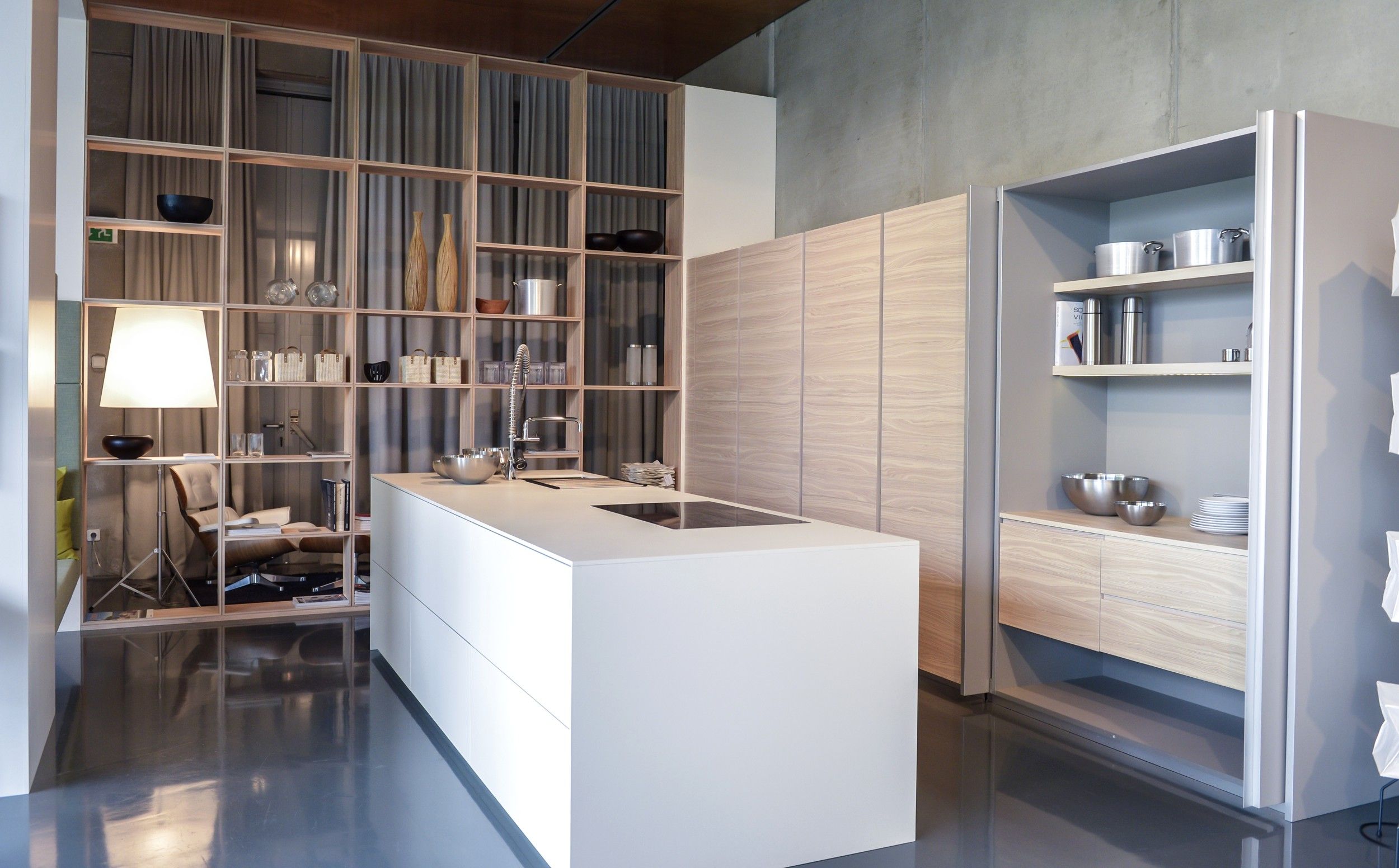 Moderne Küche mit weißer Insel, Regalen und Holzverkleidung.