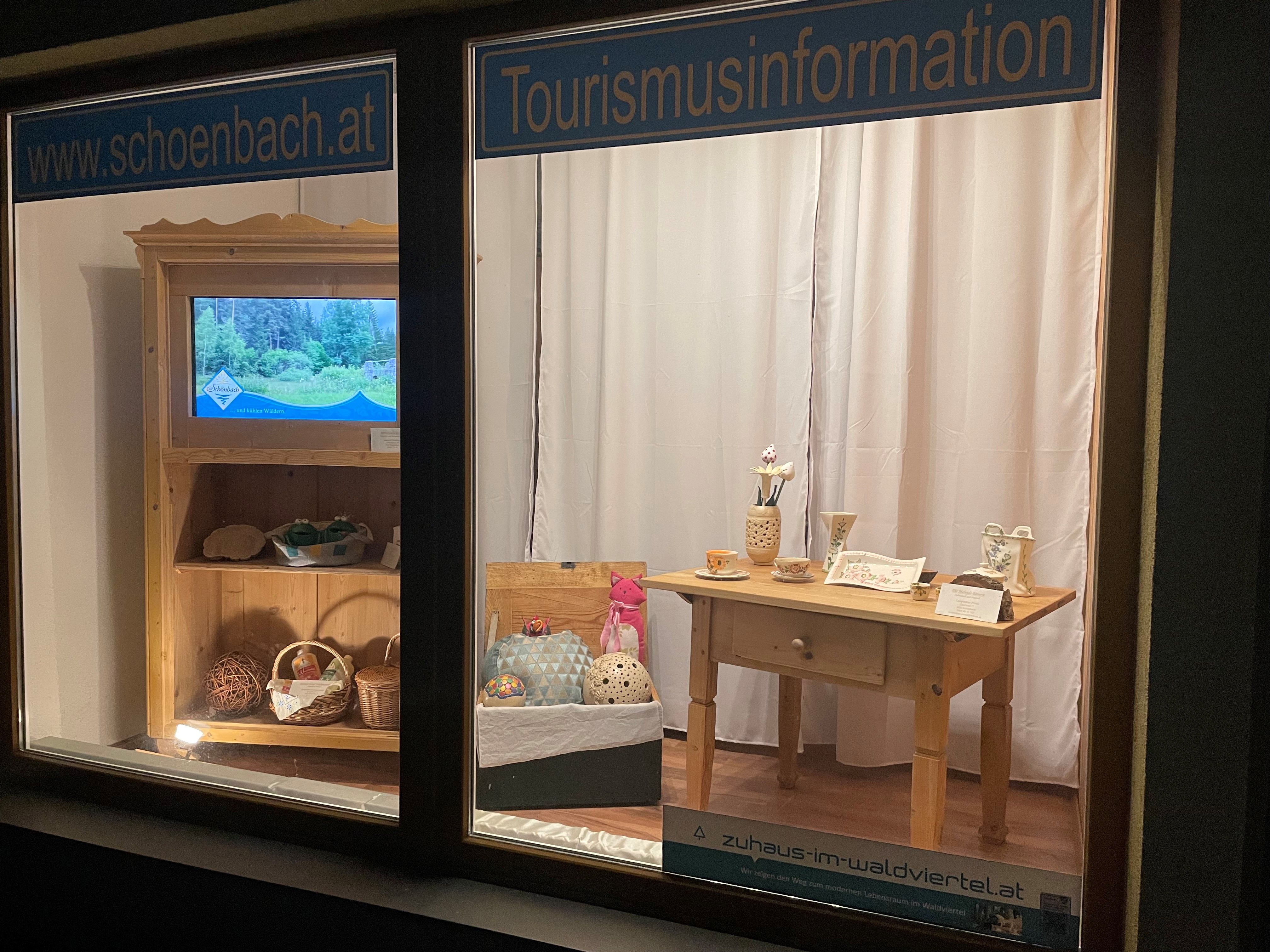 Schaufenster mit Tourismusinformationen und handgefertigten Produkten.
