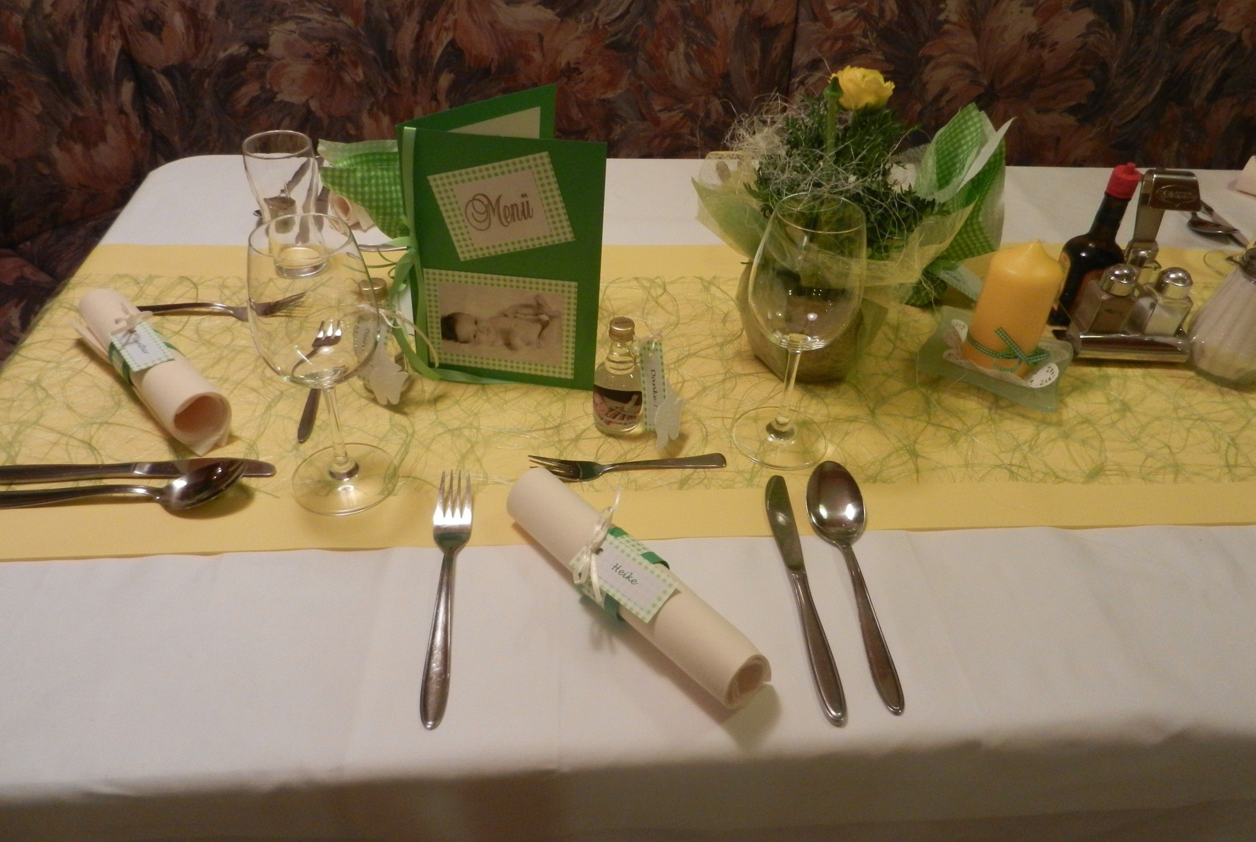 Festlich gedeckter Tisch mit Menükarte, Besteck, Gläsern und Dekoration.