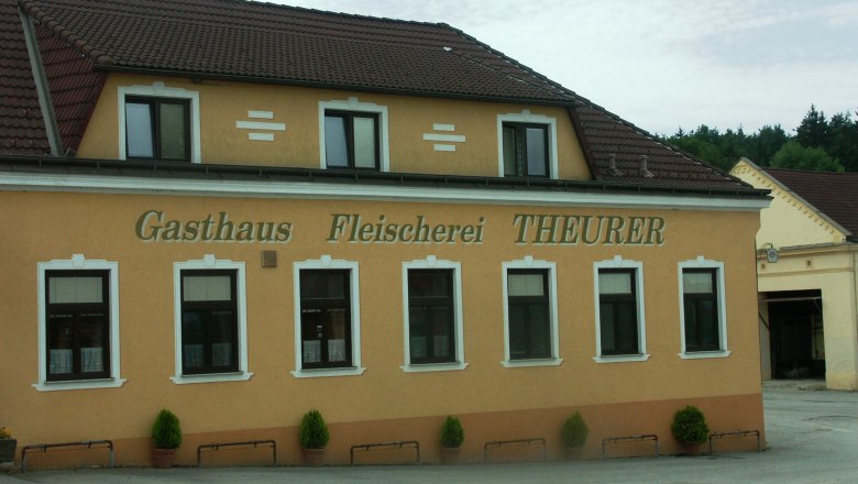 Außenansicht des Gasthauses und der Fleischerei Theurer mit gelber Fassade und braunem Dach.