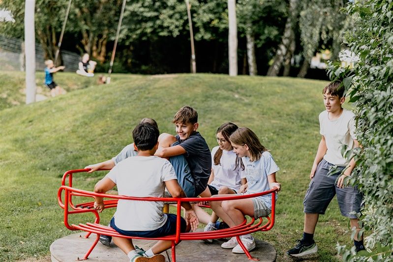 Kinder spielen auf einem Karussell im Freien.