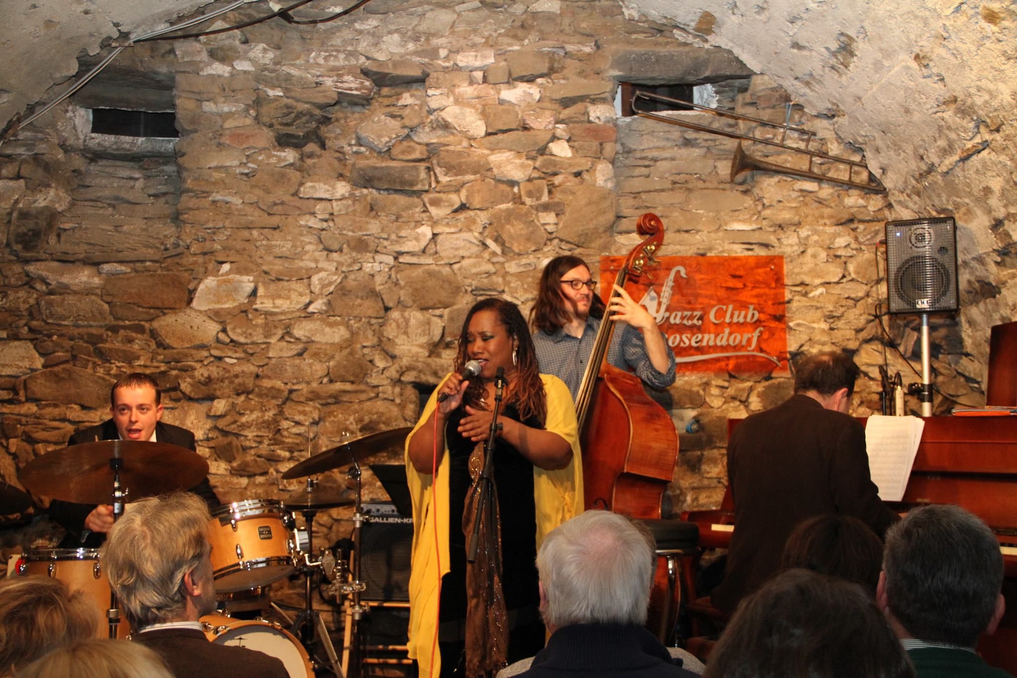 Jazzband spielt in einem rustikalen Club mit Steinwänden.