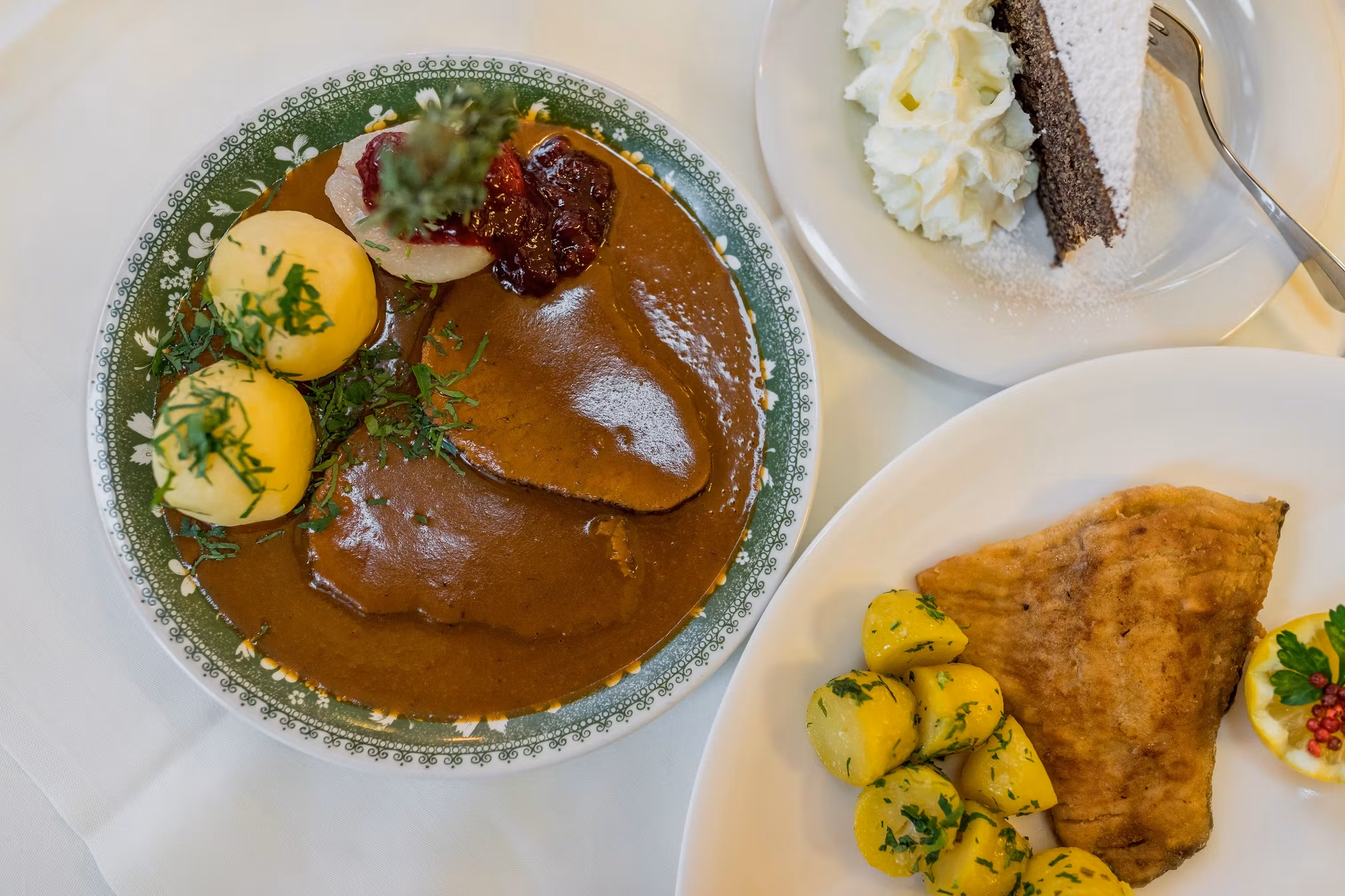 Traditionelles österreichisches Gericht mit Fleisch, Knödeln, Kartoffeln und Kuchen.