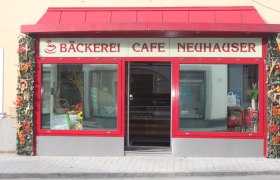 Eingang eines Cafés mit rotem Rahmen und Dekoration.