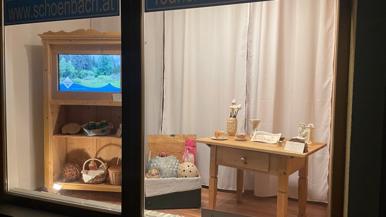 Schaufenster mit Tourismusinformationen und handgefertigten Produkten.