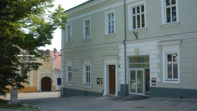 Youth center, © K-Haus A two-story, light green building with the word 'house' above the door.