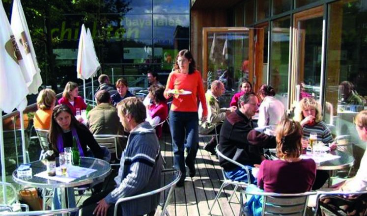 Menschen sitzen auf einer Terrasse eines Cafés im Nationalpark Thayatal.