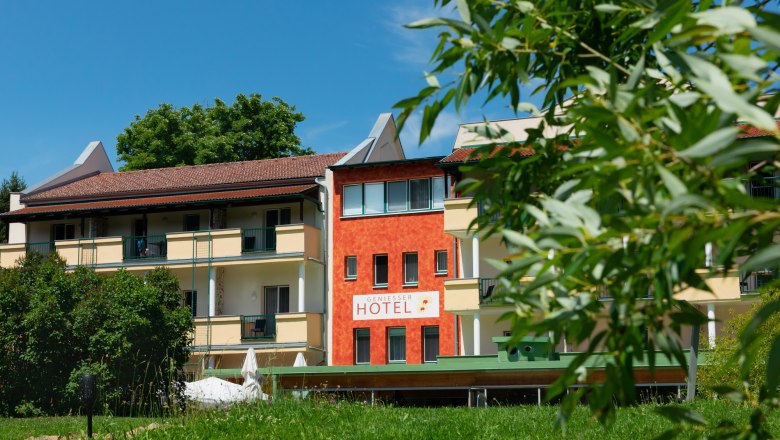 Außenansicht des Hotel-Restaurants Liebnitzmühle mit grünem Rasen und Bäumen im Vordergrund.