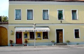 Gelbes Gebäude mit Imbiss und roten Dachziegeln.