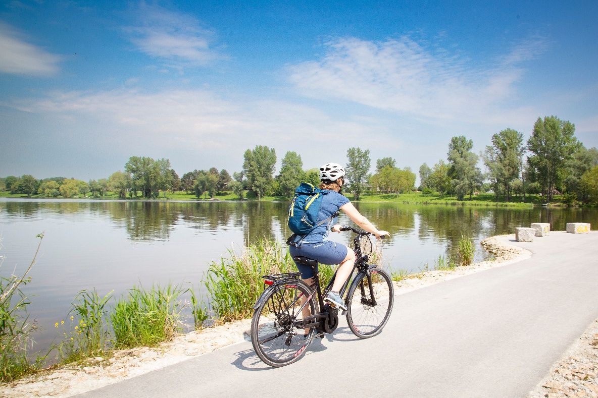 Radfahrer entlang der Donau in idyllischer Flusslandschaft