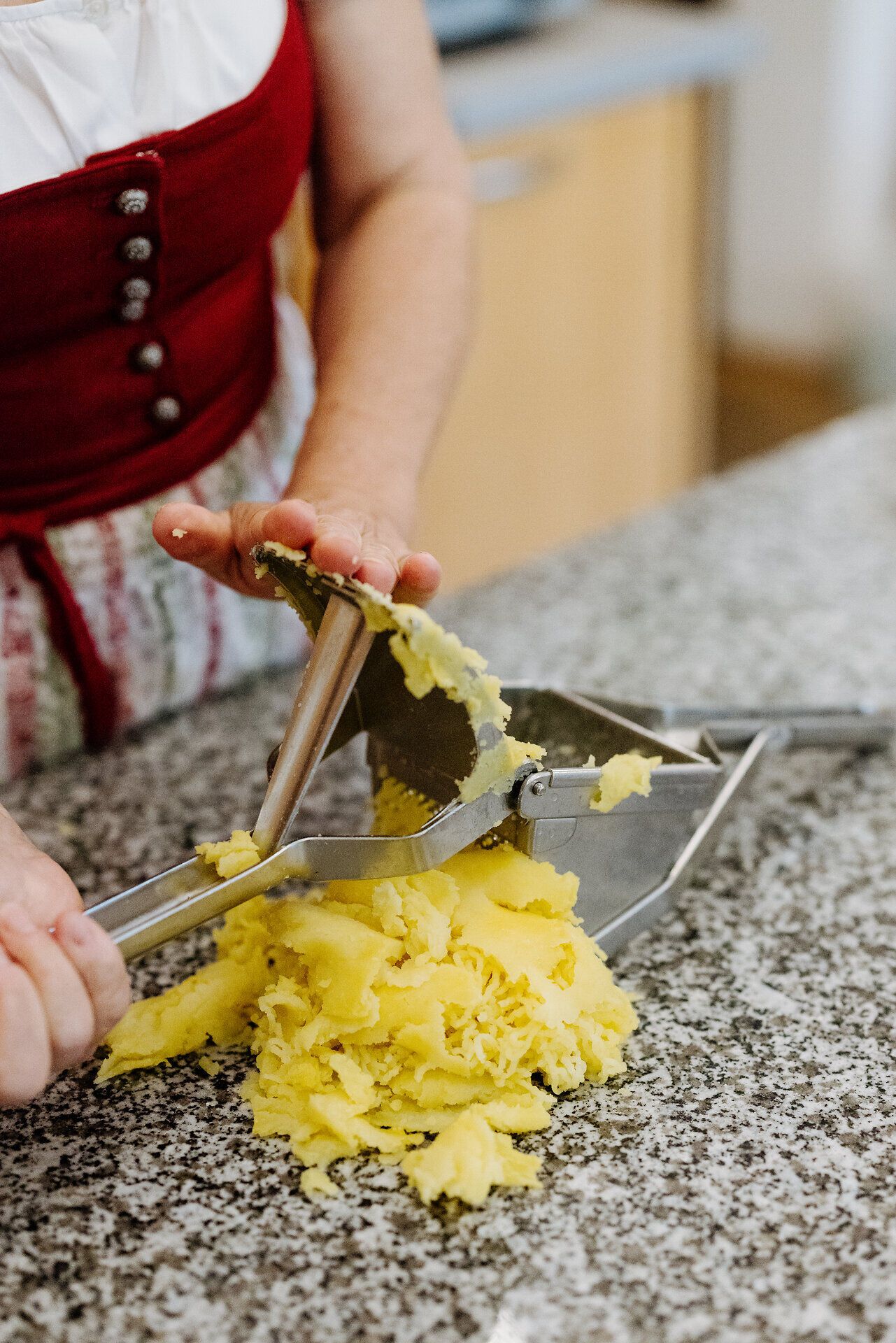 In der gemütlichen Atmosphäre des Kochkurses werden frische Kartoffeln zu einem köstlichen Teig verarbeitet. Die Hände formen mit Geschick und Leidenschaft die Grundlage für die beliebten Mohnnudeln, die hier in Armschlag eine besondere Tradition haben.