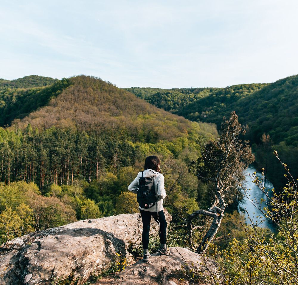 Ein atemberaubender Blick auf die üppigen, grünen Hügel und den glitzernden Fluss, der sich durch die Landschaft schlängelt, lädt zum Verweilen ein. Die frische, klare Luft und das sanfte Rauschen der Blätter schaffen eine harmonische Atmosphäre, die Wanderer und Naturliebhaber gleichermaßen begeistert.