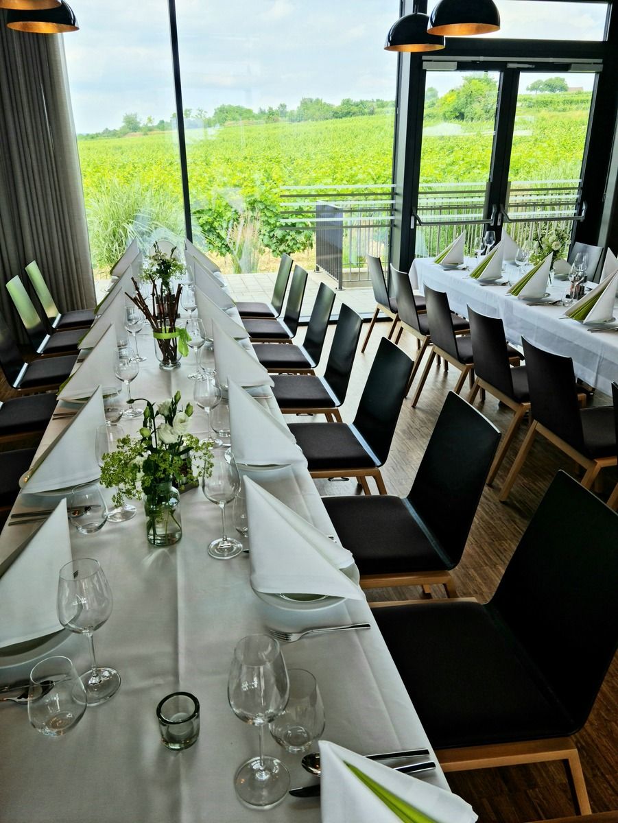 Eleganter gedeckter Tisch in einem Raum mit Blick auf Weinberge.
