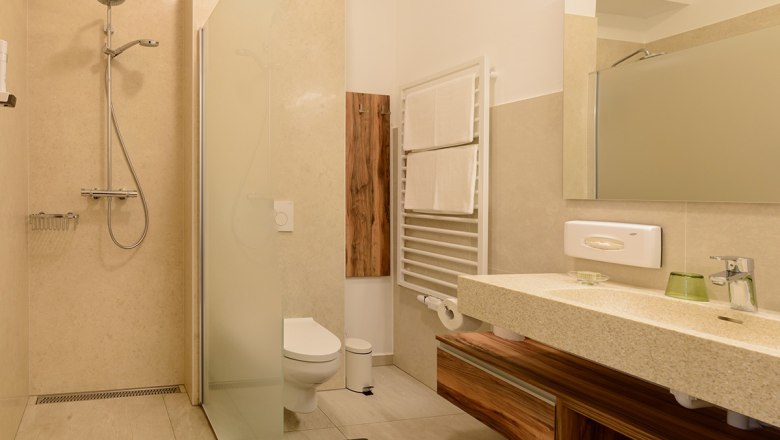 Modern bathroom with shower, WC, washbasin and towel rail.