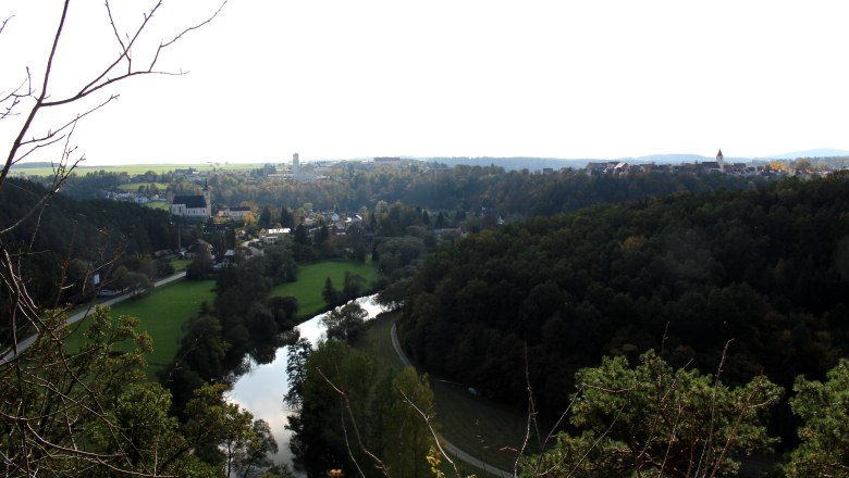 Panoramablick von der Julienhöhe auf eine Flusslandschaft mit Wald und Stadt im Hintergrund.