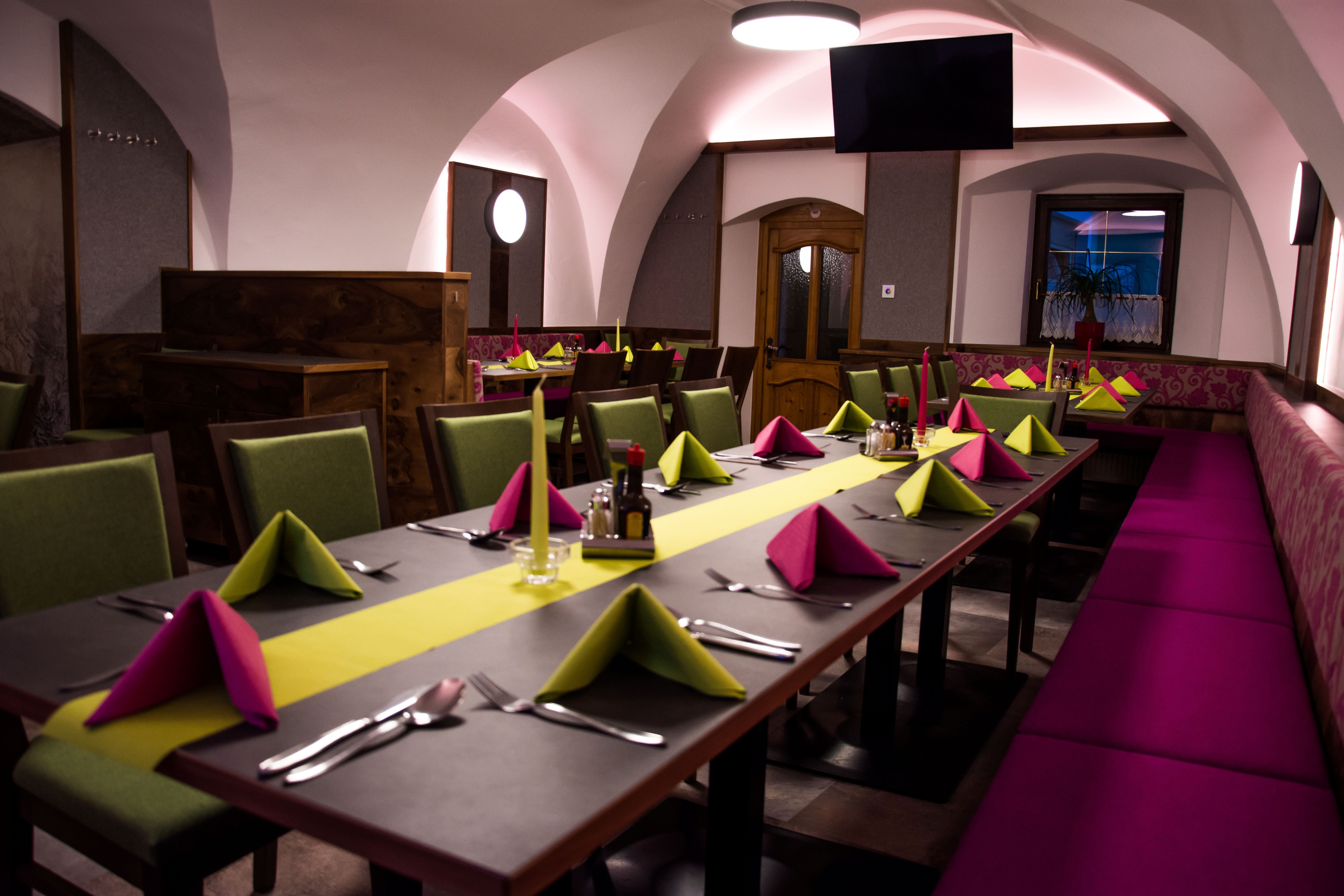 Ein stilvoll gedeckter Tisch in einem Restaurant mit bunten Servietten und Kerzen.
