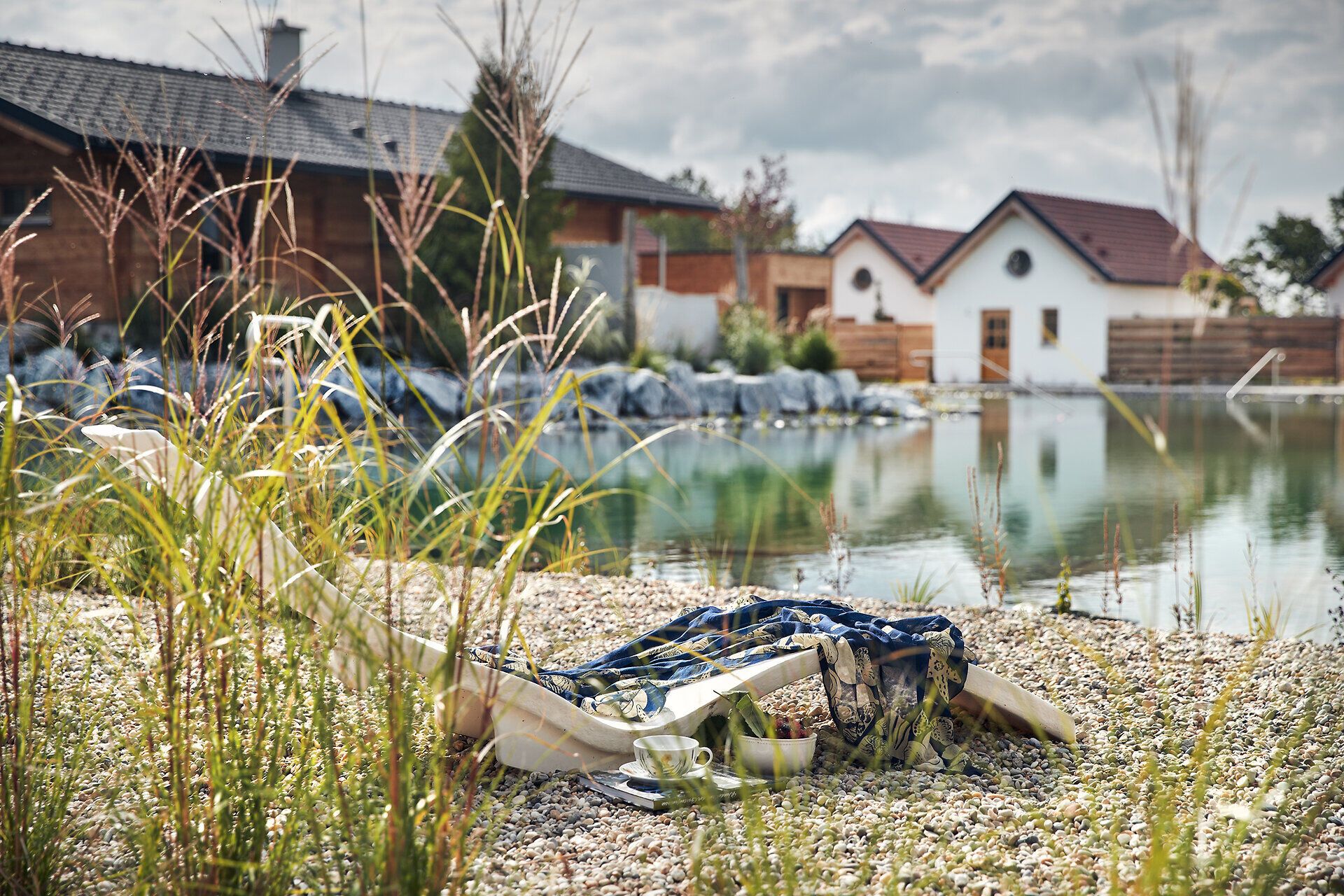Ein ruhiger Moment am Ufer des Gartensees lädt zum Entspannen ein. Die sanften Wellen spiegeln die umgebende Natur wider, während das sanfte Rascheln der Gräser eine harmonische Melodie schafft. Hier, inmitten der idyllischen Landschaft, wird der Sommer zu einem unvergesslichen Erlebnis.