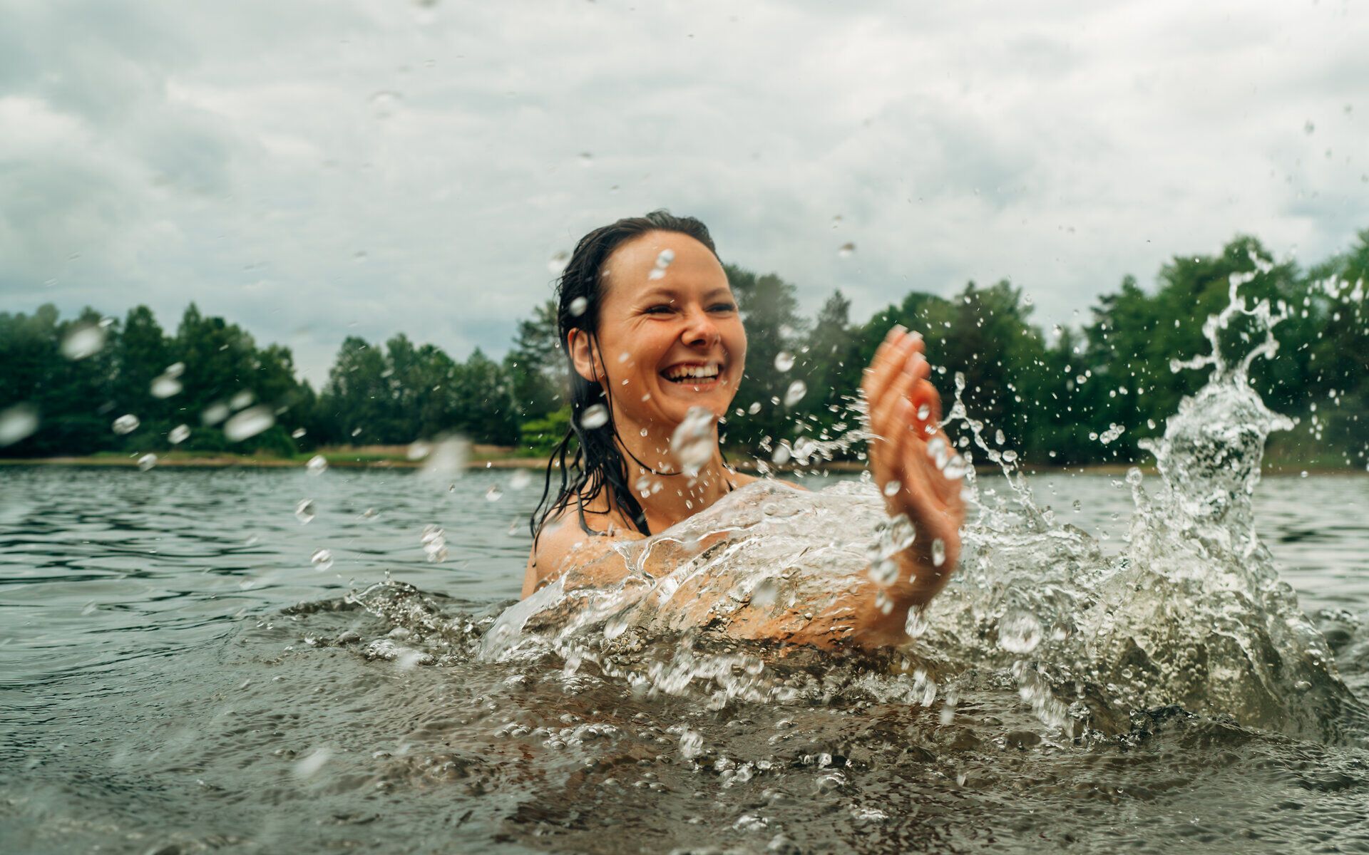 Frau im Wasser, die im Wasser planscht und sich abkühlt