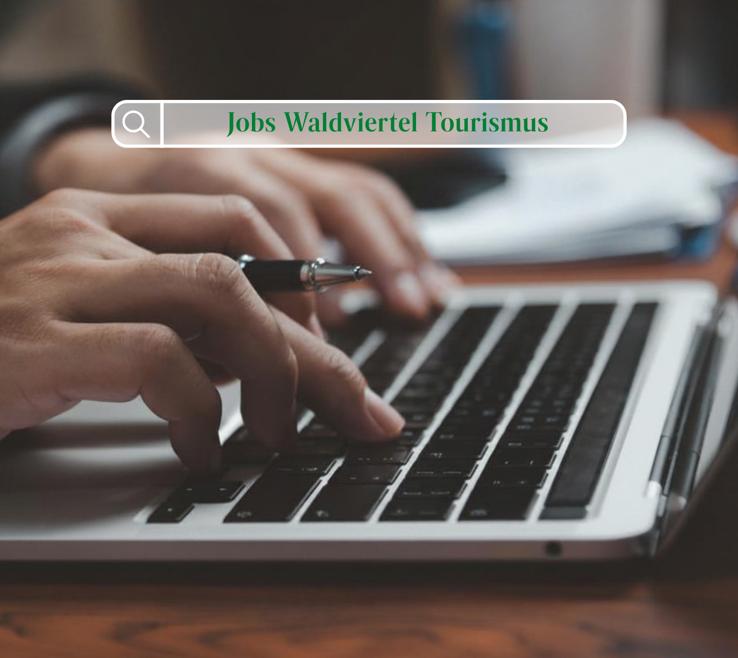 2 Hände die auf einer Tastatur tippen mit einer Suchleiste wo "Jobs Waldviertel Tourismus" steht. 