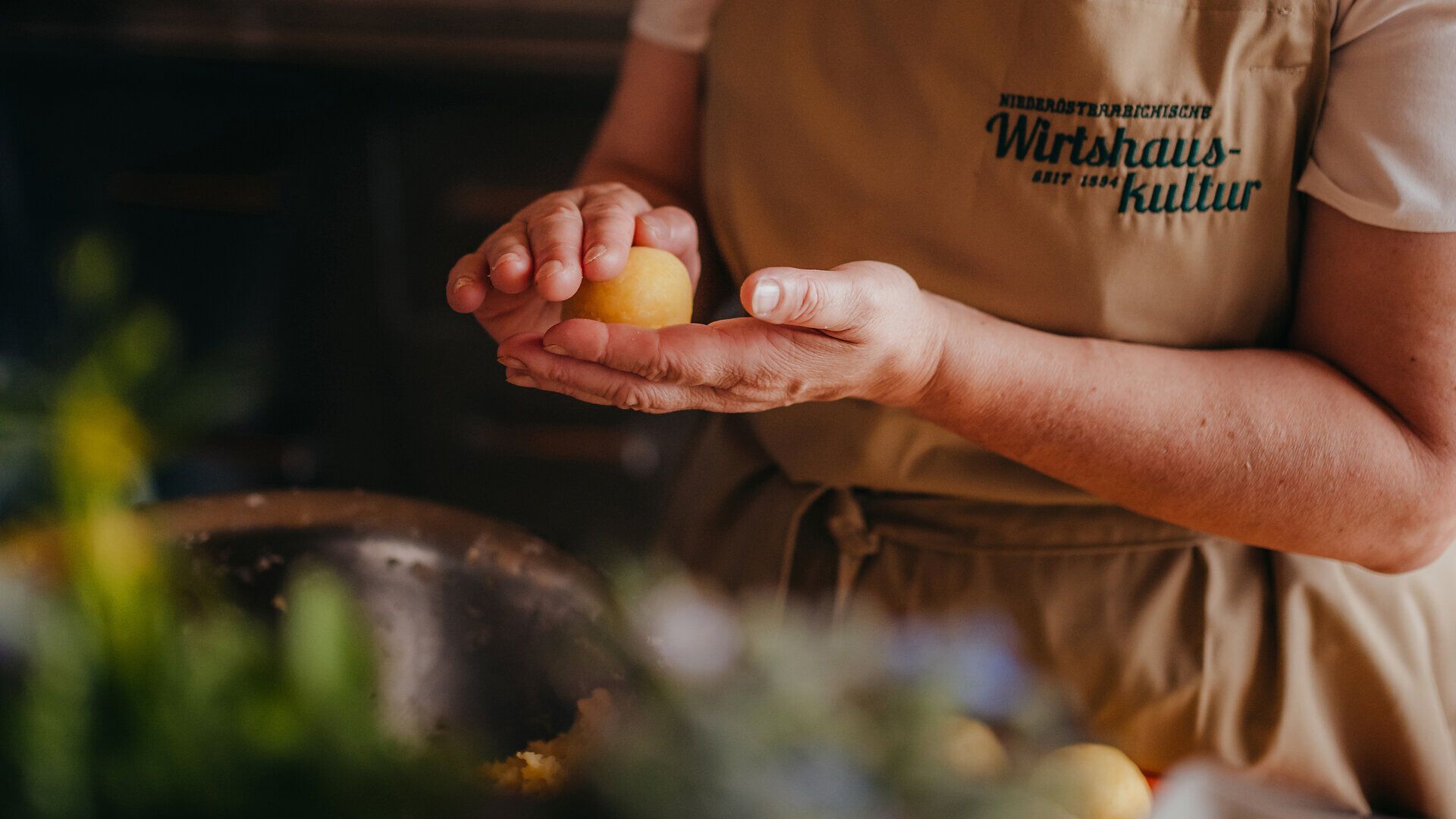 In der warmen, einladenden Atmosphäre der Wirtshausbrennerei Krenn werden frische Kartoffeln zu köstlichen Knödeln verarbeitet. Die Hände einer erfahrenen Köchin formen mit Geschick und Liebe die Zutaten, während der Duft von Tradition und regionaler Küche den Raum erfüllt. Hier im Yspertal erleben Besucher die wahre Essenz der niederösterreichischen Wirtshauskultur.