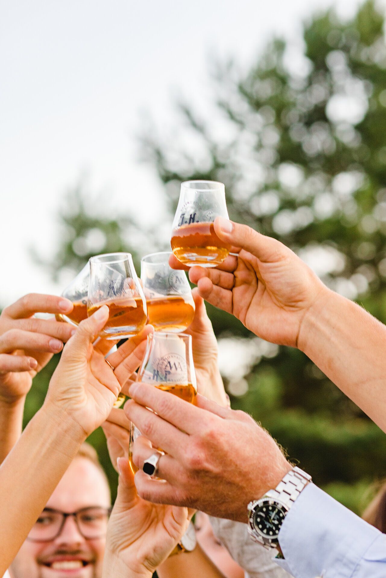Inmitten der malerischen Landschaft des Waldviertels stoßen Freunde mit Gläsern voll edlem Whisky an. Die warme Abendsonne taucht die Szene in goldenes Licht und schafft eine Atmosphäre voller Freude und Geselligkeit. Hier wird der Genuss in vollen Zügen zelebriert.