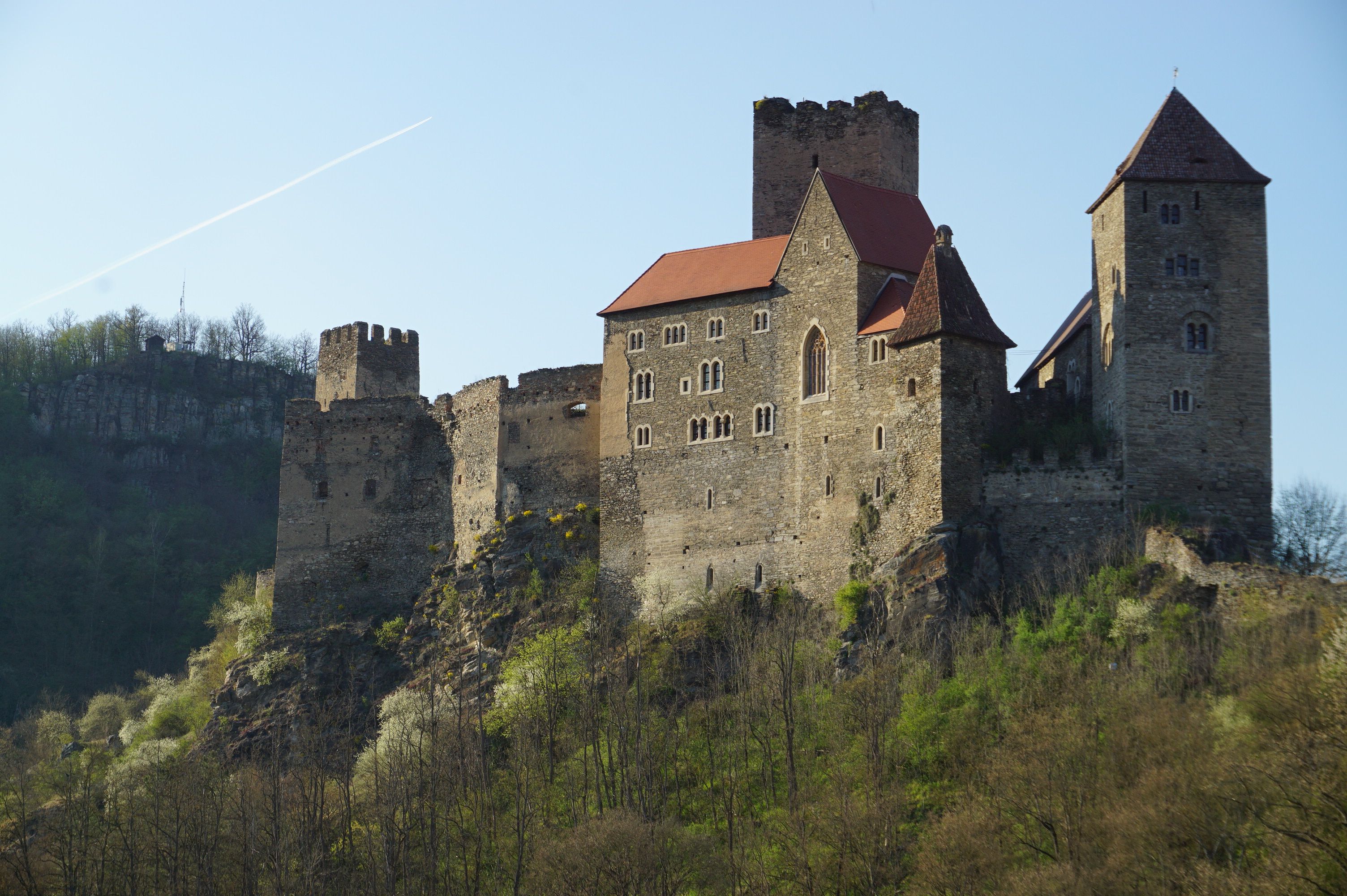 Burg Hardegg auf einem Hügel mit Bäumen im Vordergrund.