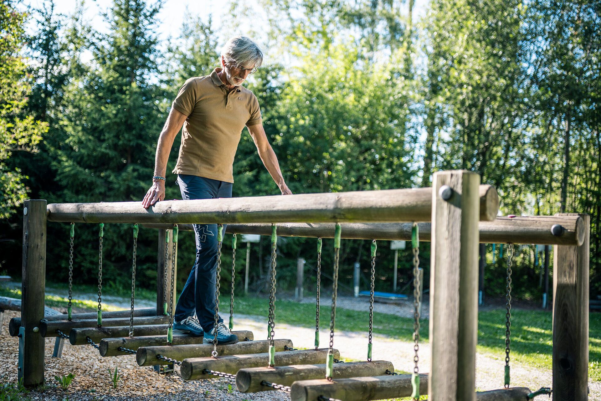 Ein Mann balanciert auf einem Holzparcours beim Herz-Kreislauf-Zentrum Groß Gerungs im Waldviertel.