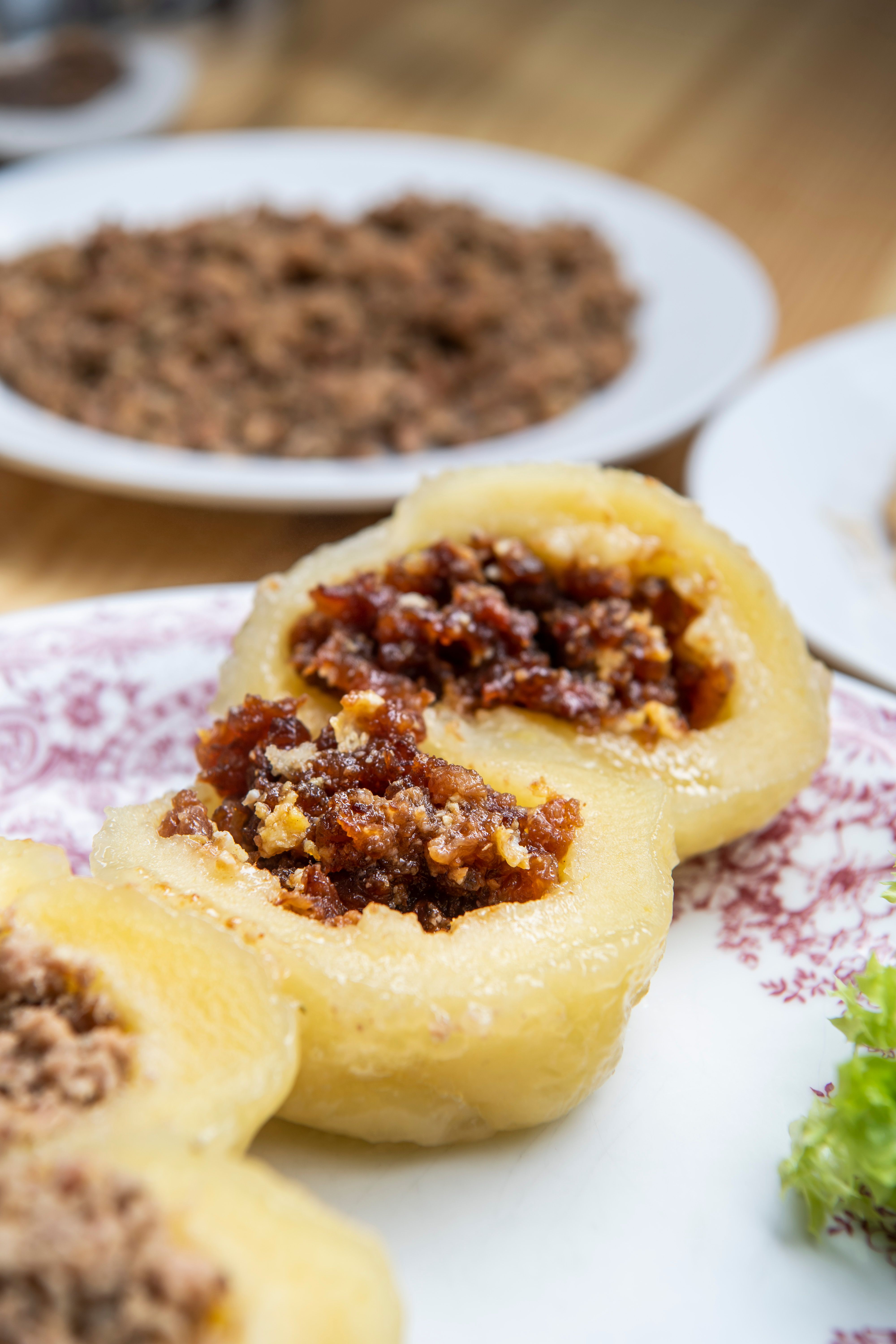 Nahaufnahme von gefüllten Knödeln auf einem Teller mit Dekoration.