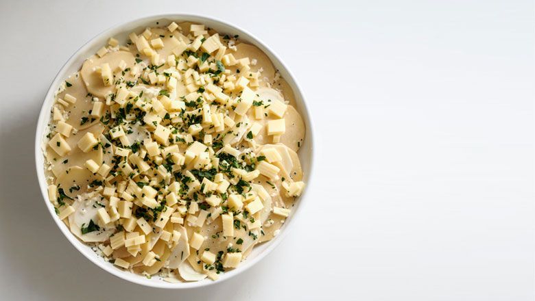 Mit Obers-Milch-Mischung übergießen, Käse und Butterflocken darüber streuen