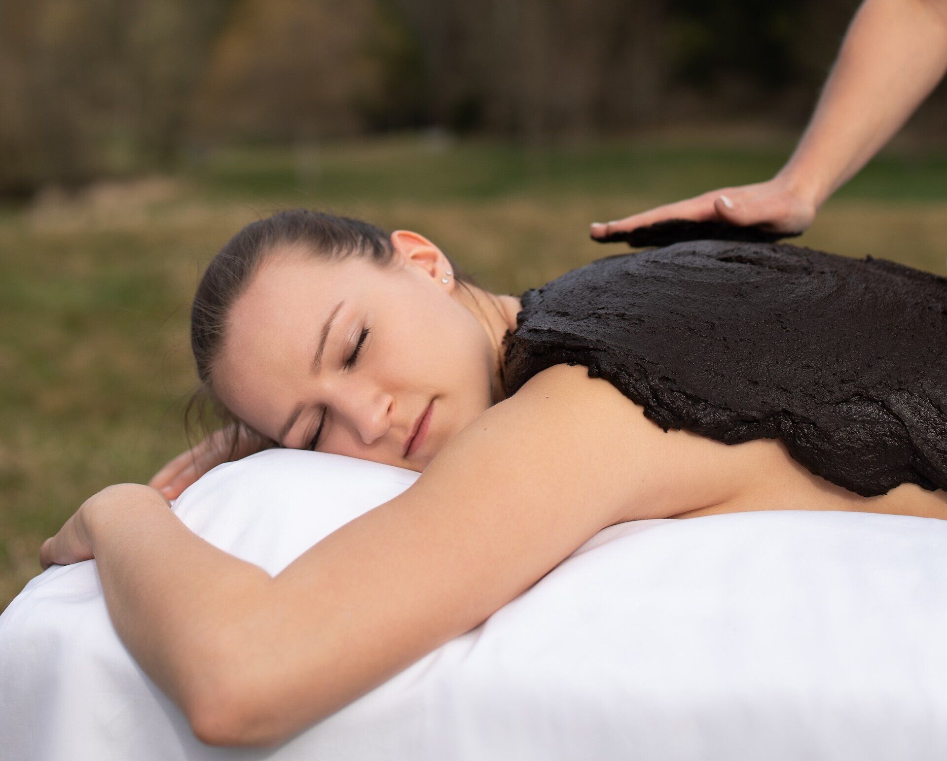 Inmitten der idyllischen Natur genießen Besucher eine entspannende Moorbehandlung, die Körper und Geist revitalisiert. Die sanften Berührungen des Therapeuten und die wohltuenden Eigenschaften des Moores schaffen eine harmonische Atmosphäre, die zum Verweilen einlädt.