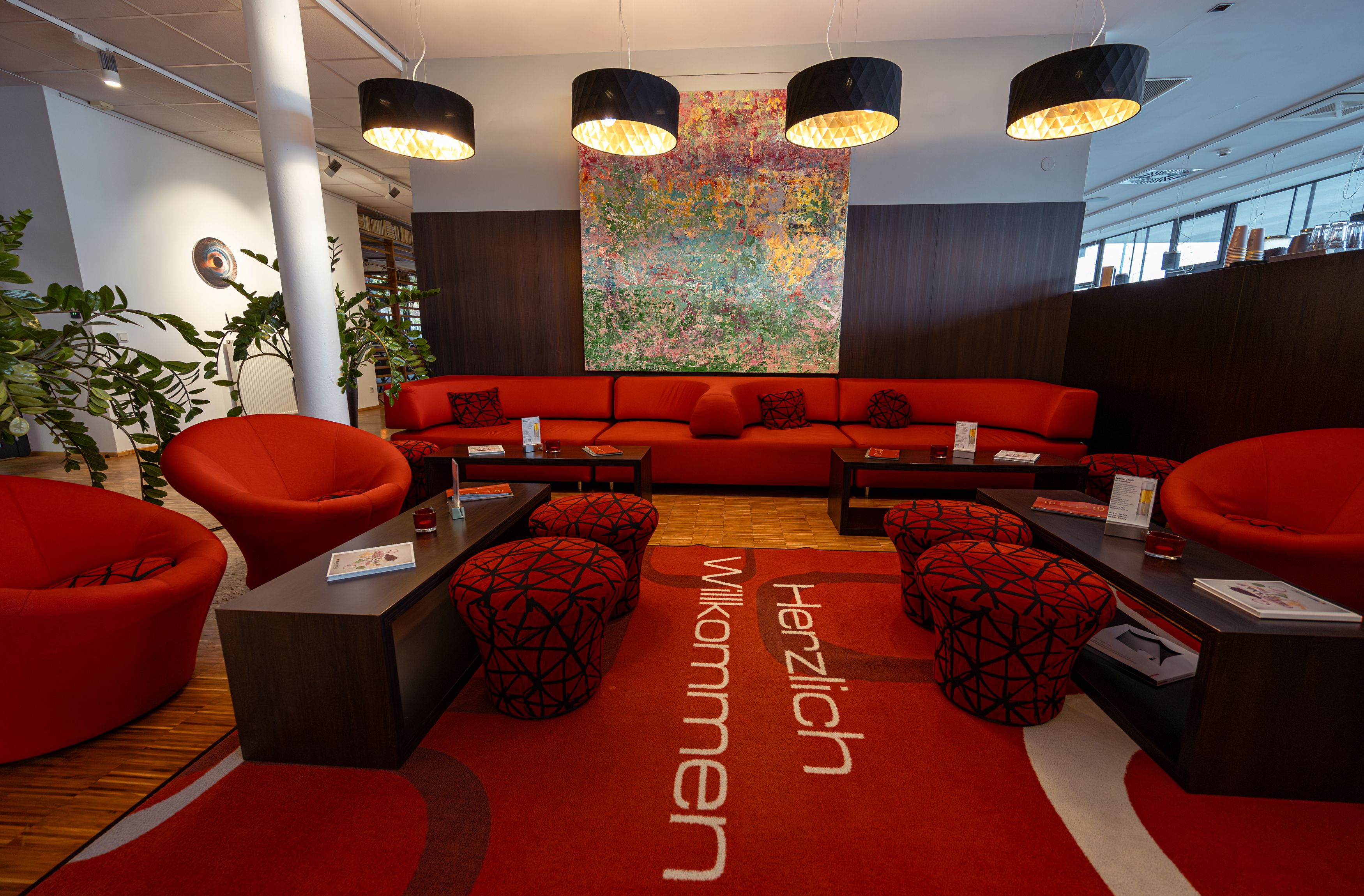 Moderne Hotellobby mit roten Möbeln und Kunstwerk an der Wand.