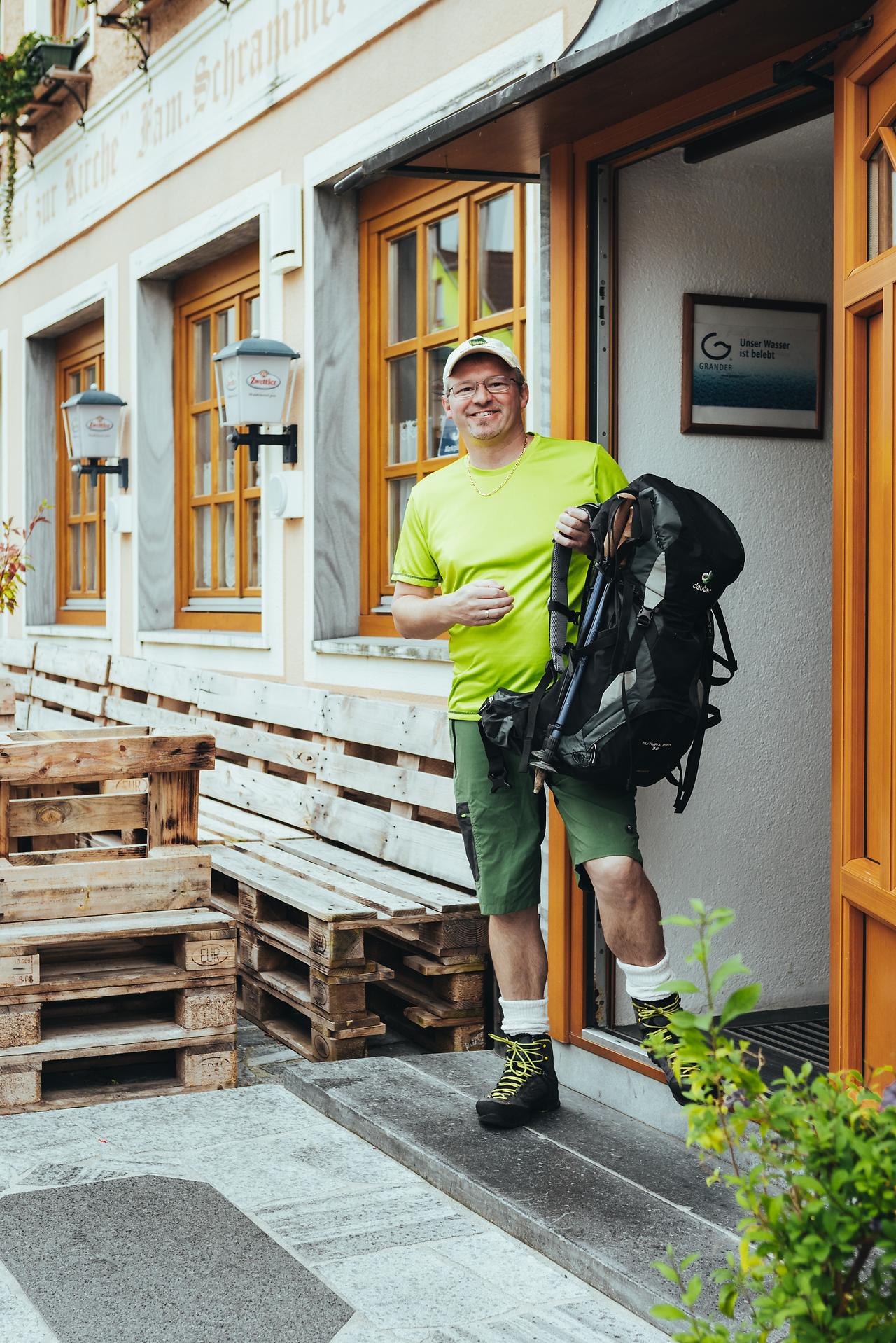 Ein Wanderer tritt mit einem Lächeln aus dem Gasthof, bereit für ein neues Abenteuer in der malerischen Landschaft des Waldviertels. Die frische Bergluft und die strahlende Sonne laden dazu ein, die umliegenden Hügel und Wälder zu erkunden. Hier, wo Gastfreundschaft und Natur aufeinandertreffen, beginnt ein unvergesslicher Tag.